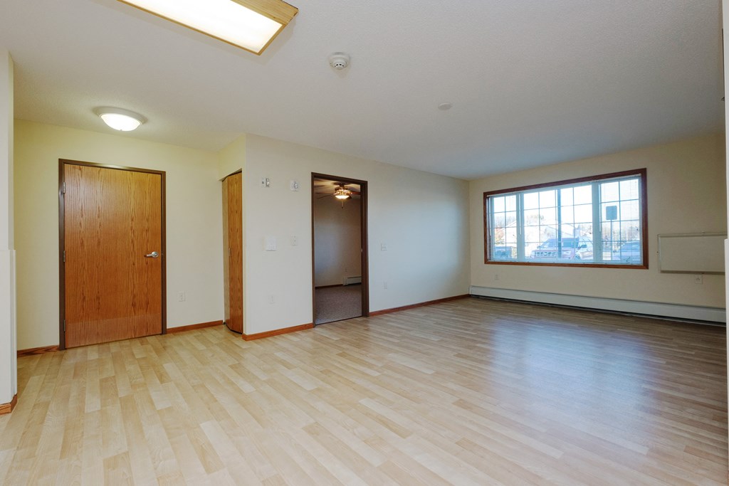 a living room with the entry door and a window.