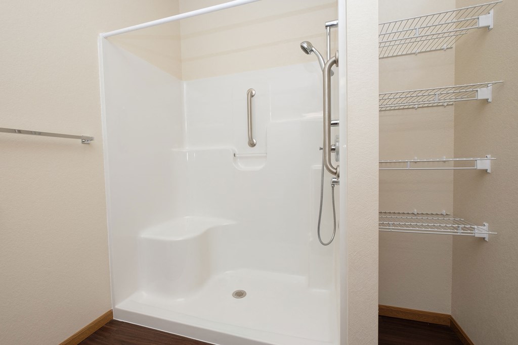 a bathroom with a shower and a closet. Fargo, ND North Sky Apartments