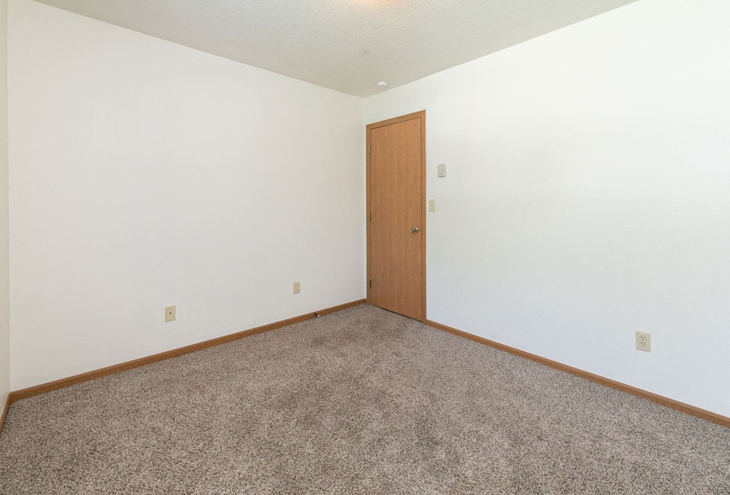a bedroom with white walls and carpet. Fargo, ND White Ridge Apartments