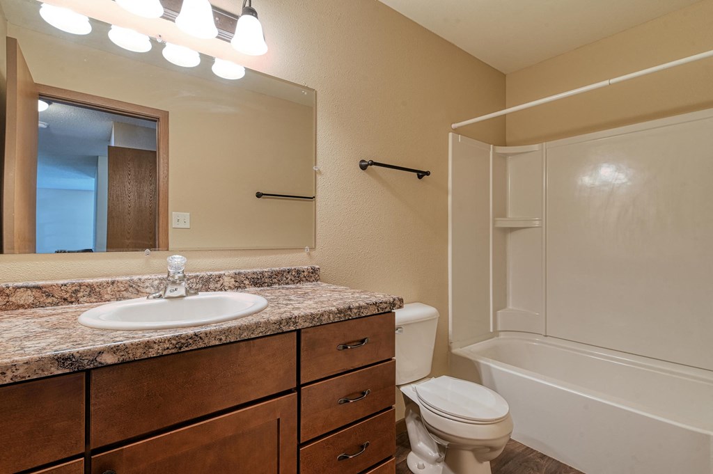 Grand Forks, ND Madison Apartments. A bathroom with a sink, toilet, and bathtub.