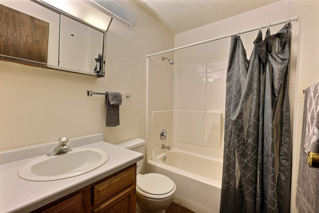 a bathroom with a shower sink and toilet. Fargo, ND Kingswood Apartments