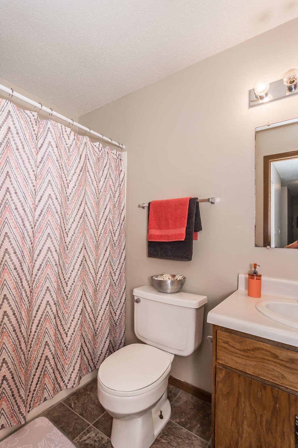 Grand Forks, ND Library Lane Apartments a bathroom with a white sink and toilet next to a shower with a red and gray che
