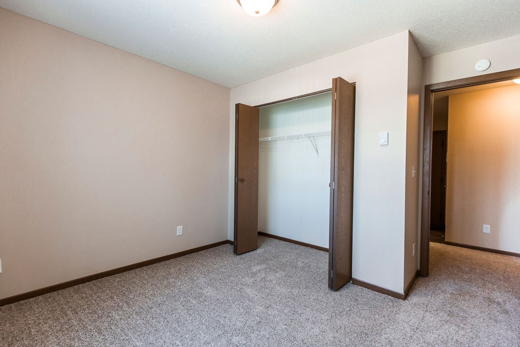 Grand Forks, ND Library Lane Apartments a bedroom with a closet and an open door