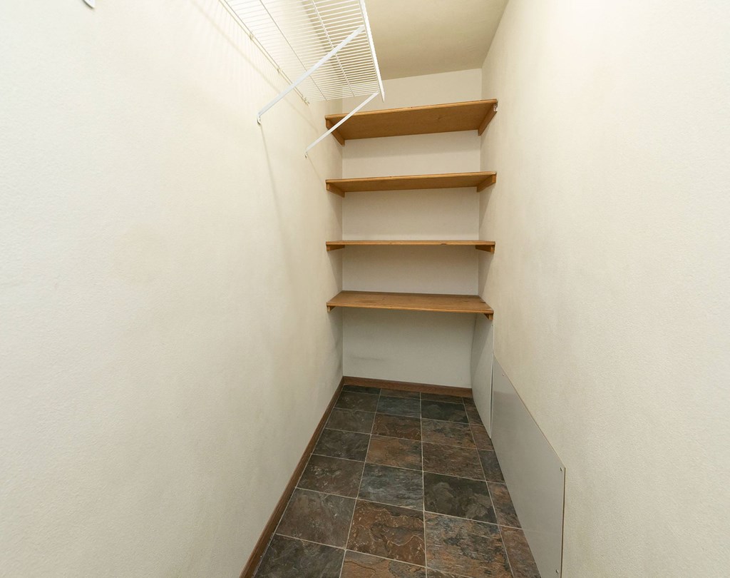 a walk in closet with shelves and a white wall. Fargo, ND Islander Apartments