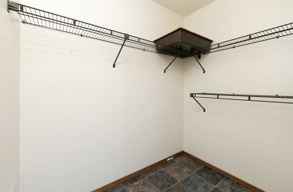 a room with two hanging racks on the wall and a tile floor. Fargo, ND Maplewood Bend Apartments