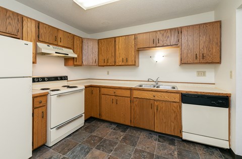 a kitchen with white appliances and wooden cabinets