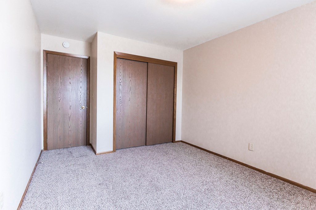 Grand Forks, ND Mayfair Apartments a bedroom with two doors and a carpeted floor