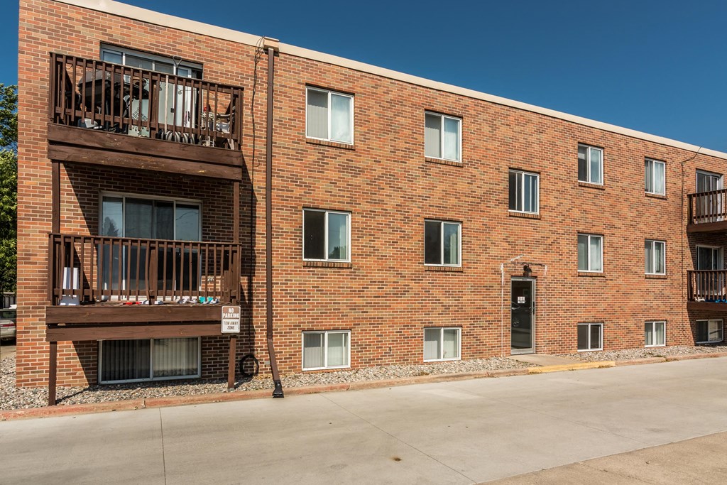 Grand Forks, ND Mayfair Apartments a brick building with two balconies and a street in front of it