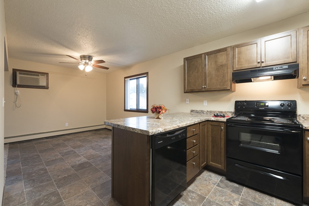 a kitchen with black appliances and a granite counter top. Bismarck, ND Newgate Apartments