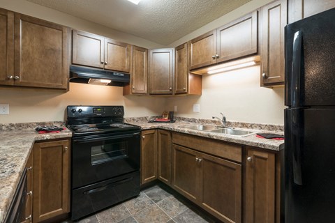 a kitchen with black appliances and white countertops. Bismarck, ND Newgate Apartments