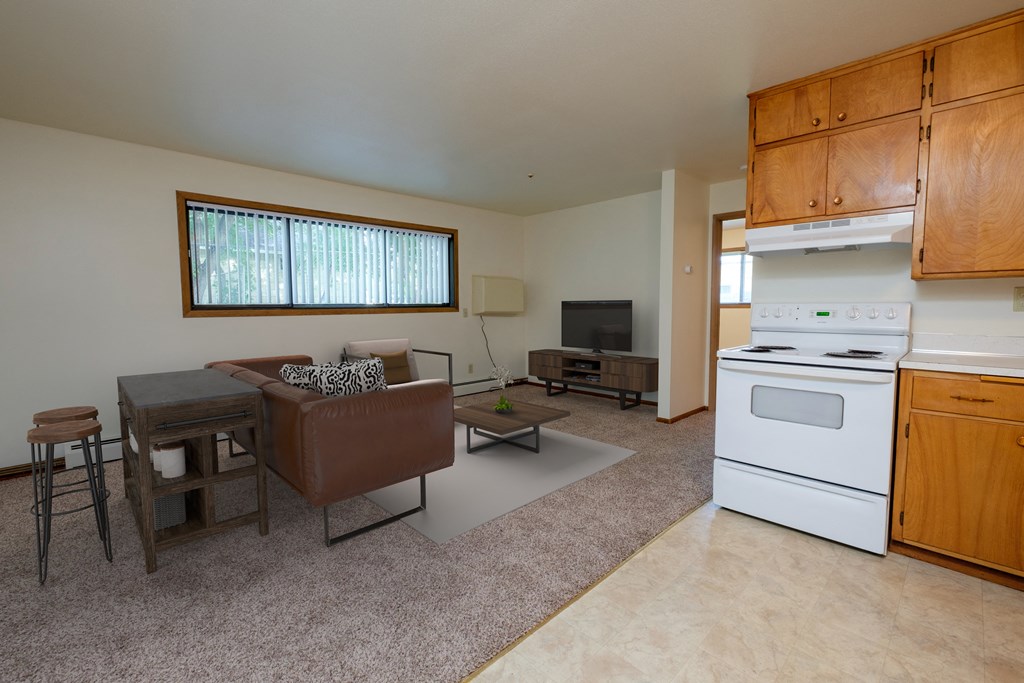an open living room with a kitchen. Moorhead, MN Northwood Apartments