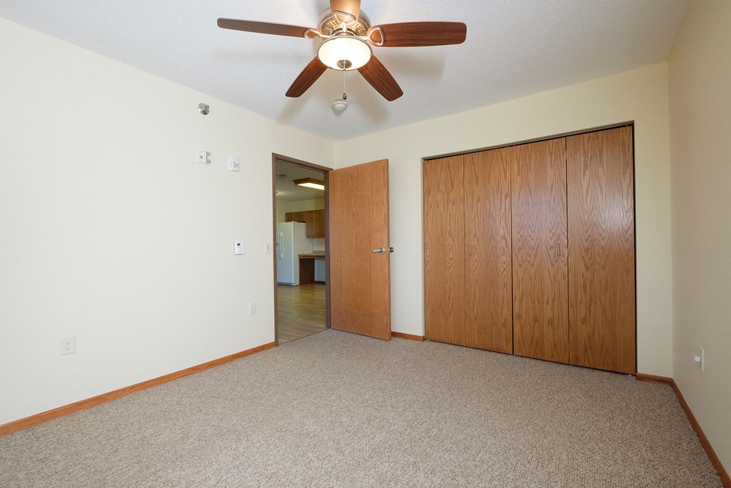 a bedroom with a closet and ceiling fan. Fargo, ND Crossroads Apartments