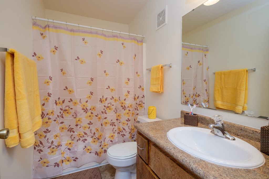 Bathroom with a sink and a toilet and a shower at Oak Court Apartments, ND