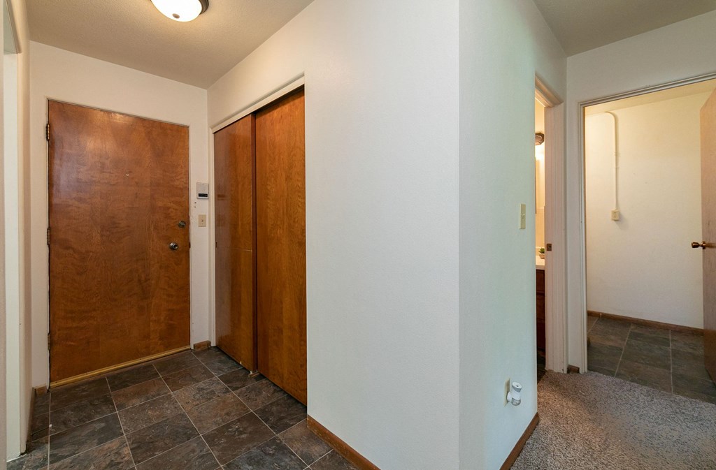 the hallway of a home with two doors and a tile floor. Fargo, ND Islander Apartments
