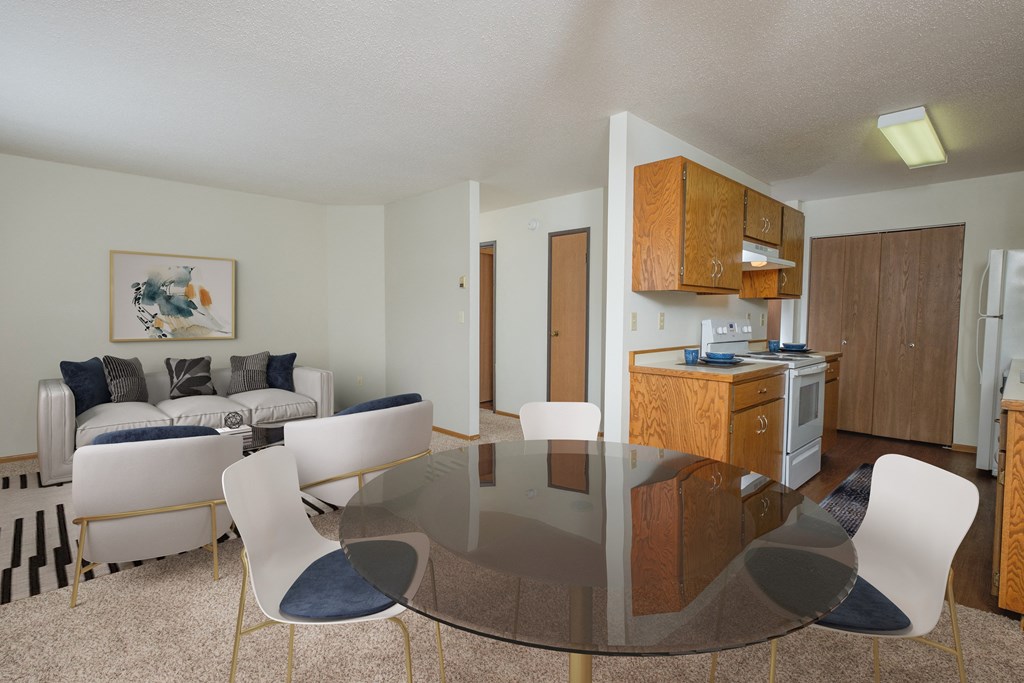 Fargo, ND Park Circle Apartments. a living room with a glass table and chairs and a kitchen with a stove and oven