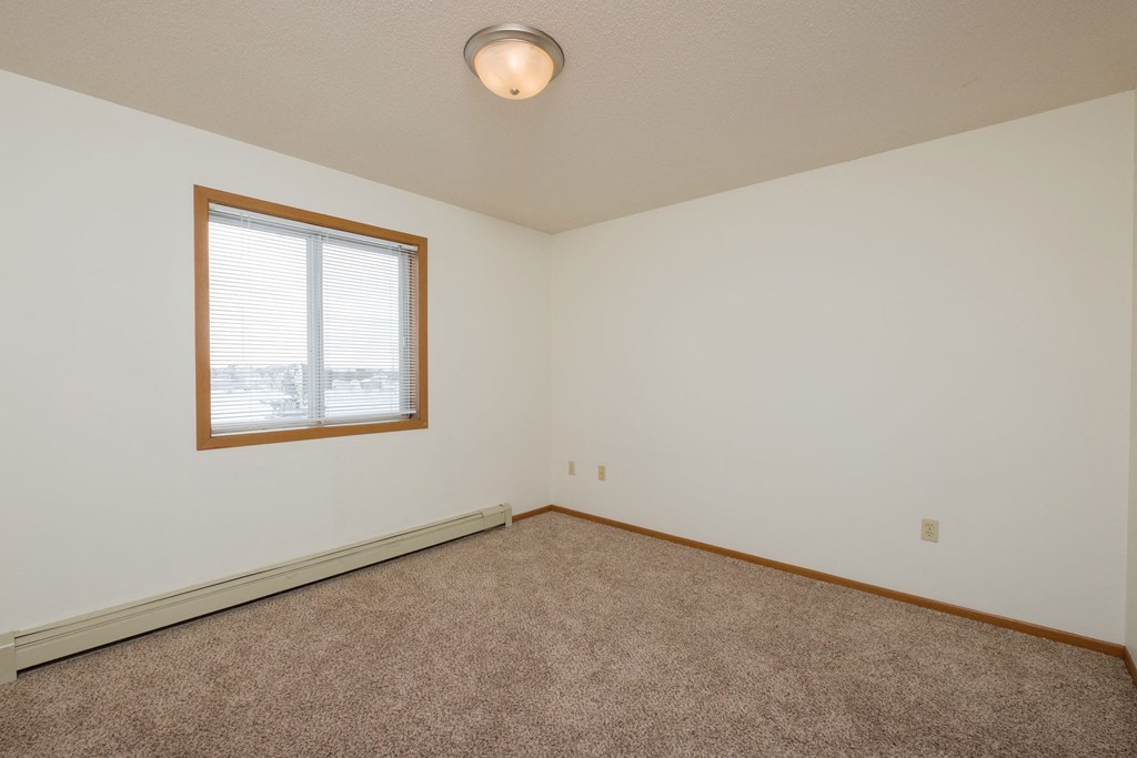 A bedroom with a window and a carpeted floorFargo, ND Park Circle Apartments | Kitchen