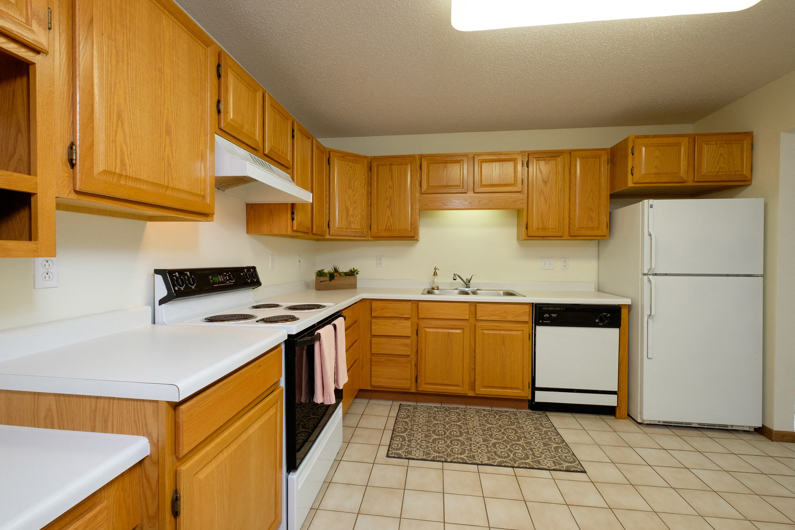 A kitchen with white appliances. Pinehurst Apartments