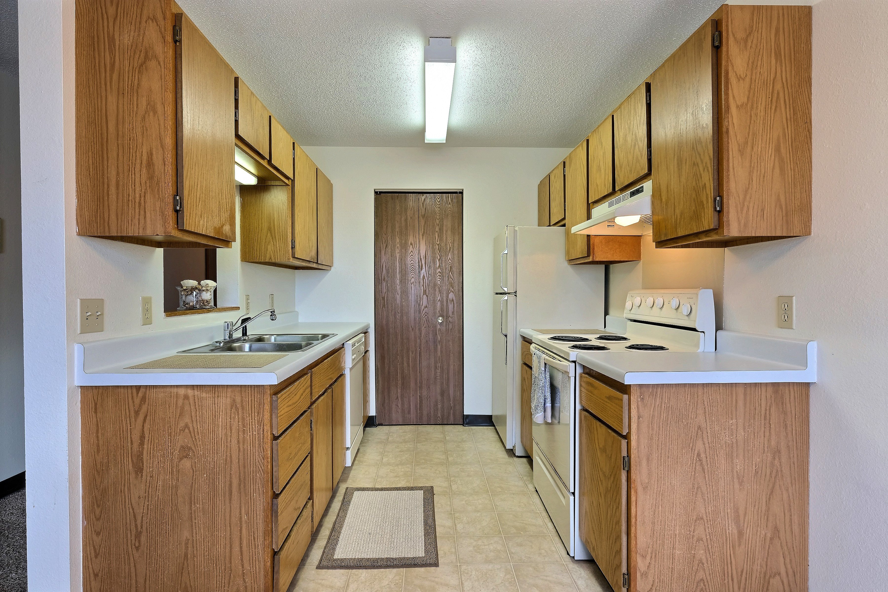 a kitchen with white appliances and wooden cabinets. Fargo, ND Prairiewood Meadows