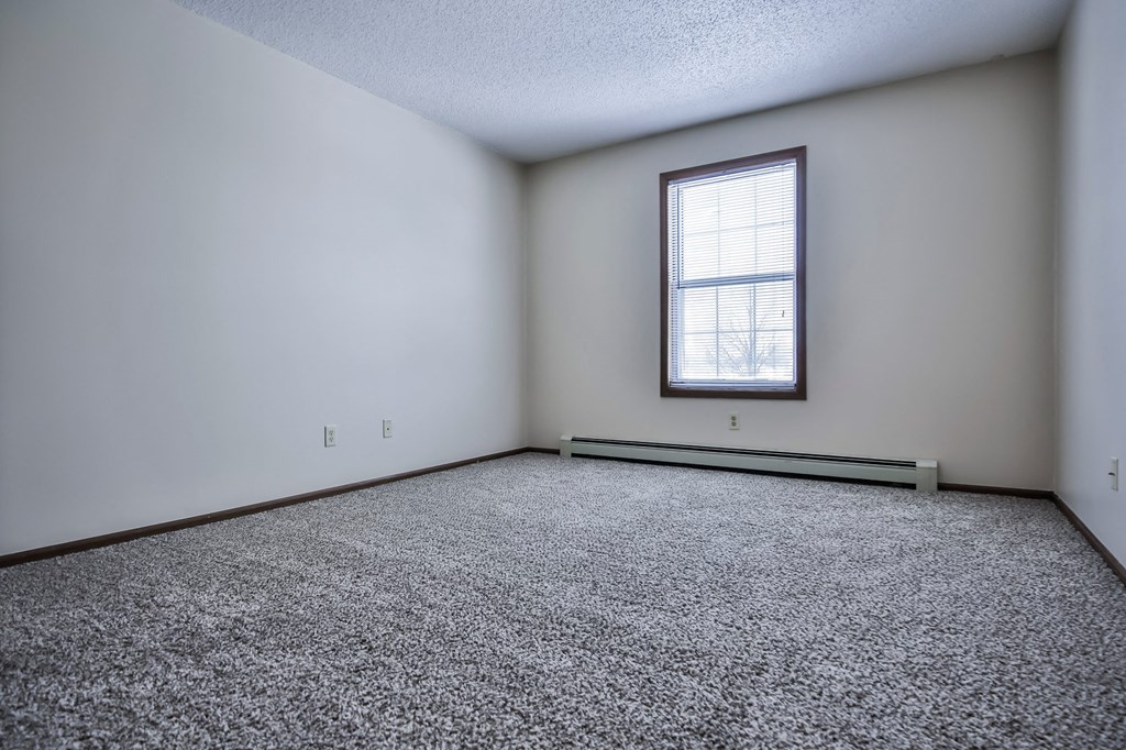 Grand Forks Primrose Apartments an empty room with a window and carpet