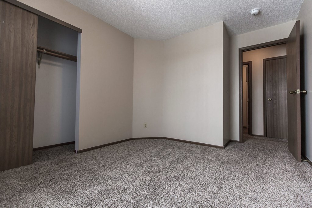 Grand Forks Primrose Apartments a small bedroom with two doors and a carpeted floor