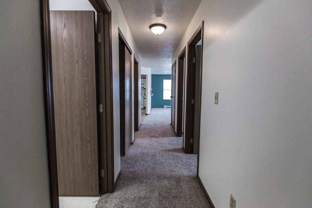 Grand Forks Primrose Apartments. A look down the hallway of an apartment with bedrooms and a bathroom