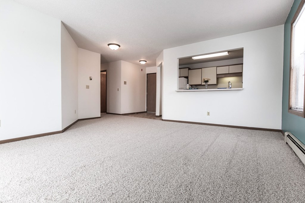 Grand Forks Primrose Apartments. An empty living room with a kitchen in the background