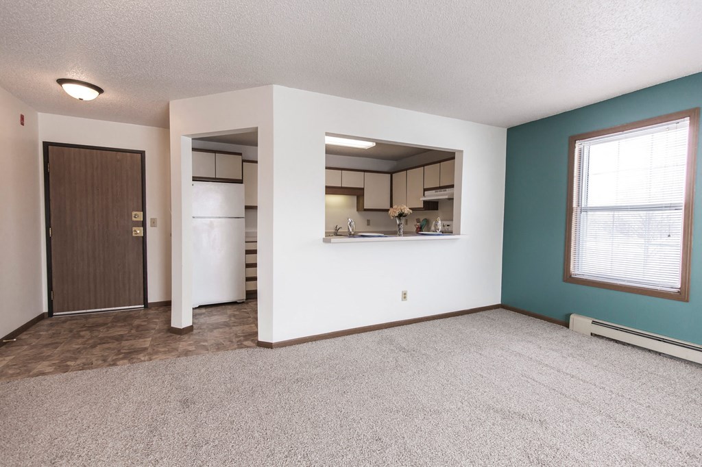 Grand Forks Primrose Apartments. An empty living room with a kitchen in the background
