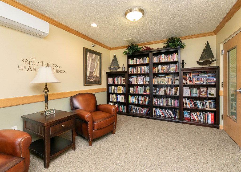 a library with comfy chairs and a large bookshelf. Fargo, ND Sunrise North