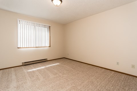 Grand Forks, ND Richfield Apartments. A bedroom with a window and carpeted floors