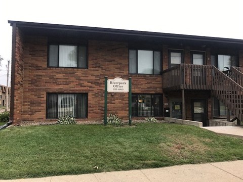 a brick building with a sign in front of it. Bismarck, ND Riverpark Apartments