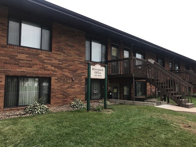 a building with a sign in front of it. Bismarck, ND Riverpark Apartments