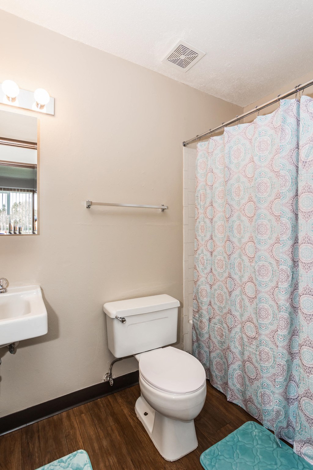 Grand Forks, ND Riverwood Apartments.  A bathroom with a shower curtain and a toilet and a sink