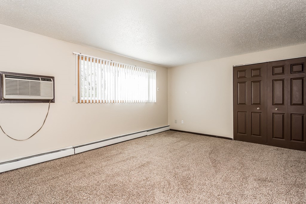 Grand Forks, ND Riverwood Apartments. A living room with an air conditioner and a door