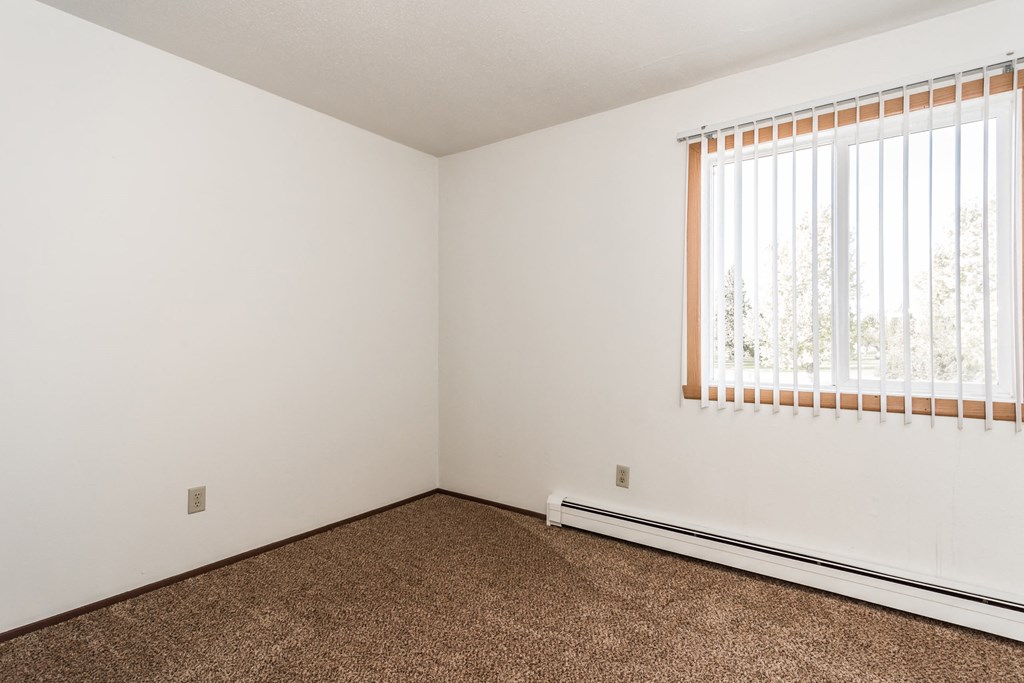Grand Forks, ND Riverwood Apartments. A bedroom with carpet and a window