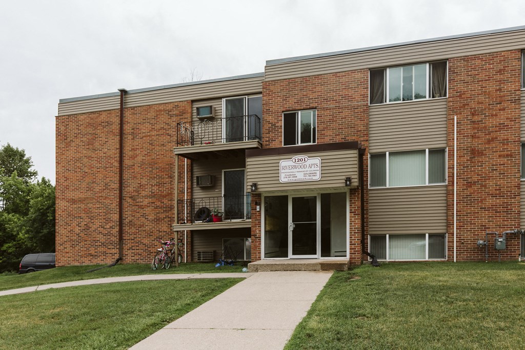 Grand Forks, ND Riverwood Apartments. A brick apartment building with a sidewalk and a bike parked in front