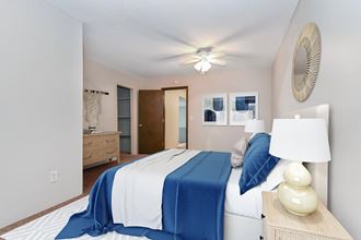 a bedroom with a bed and a dresser  at Rosedale Estates Apartments, Roseville, MN
