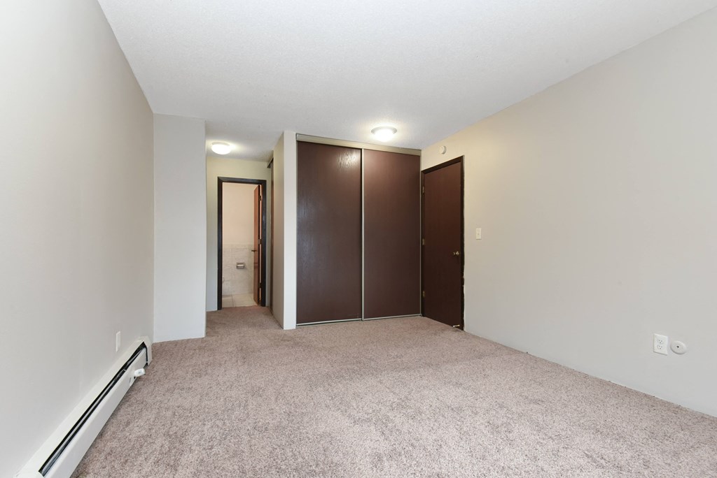 a bedroom with carpet and doors to a closet. Roseville, MN Rosedale Estates
