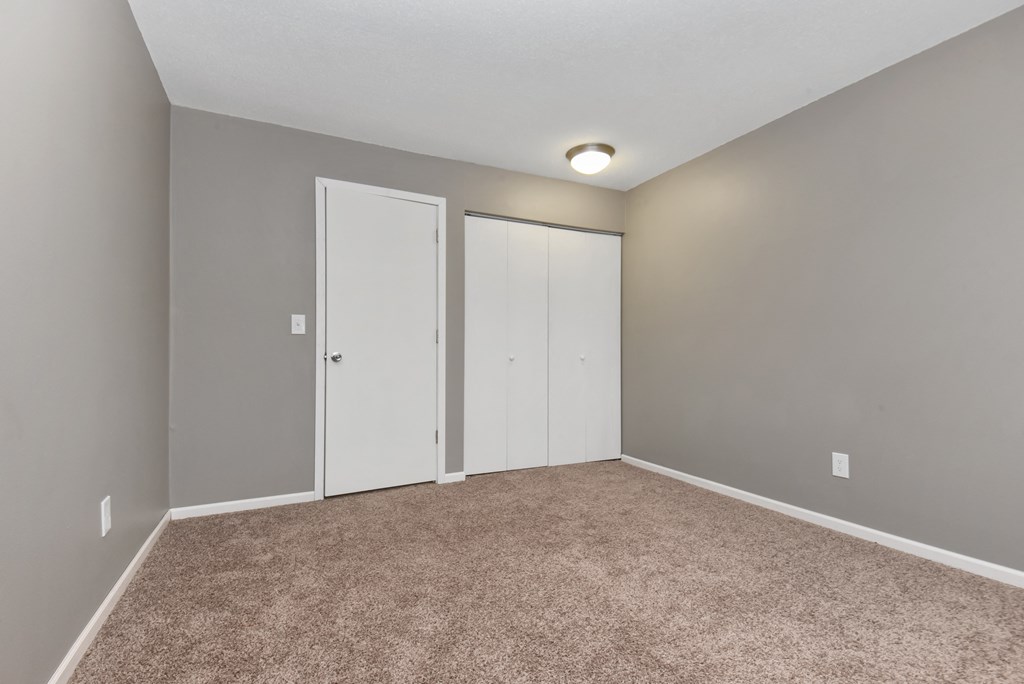 an empty room with carpet and two closet doors. Roseville, MN Rosedale Estates
