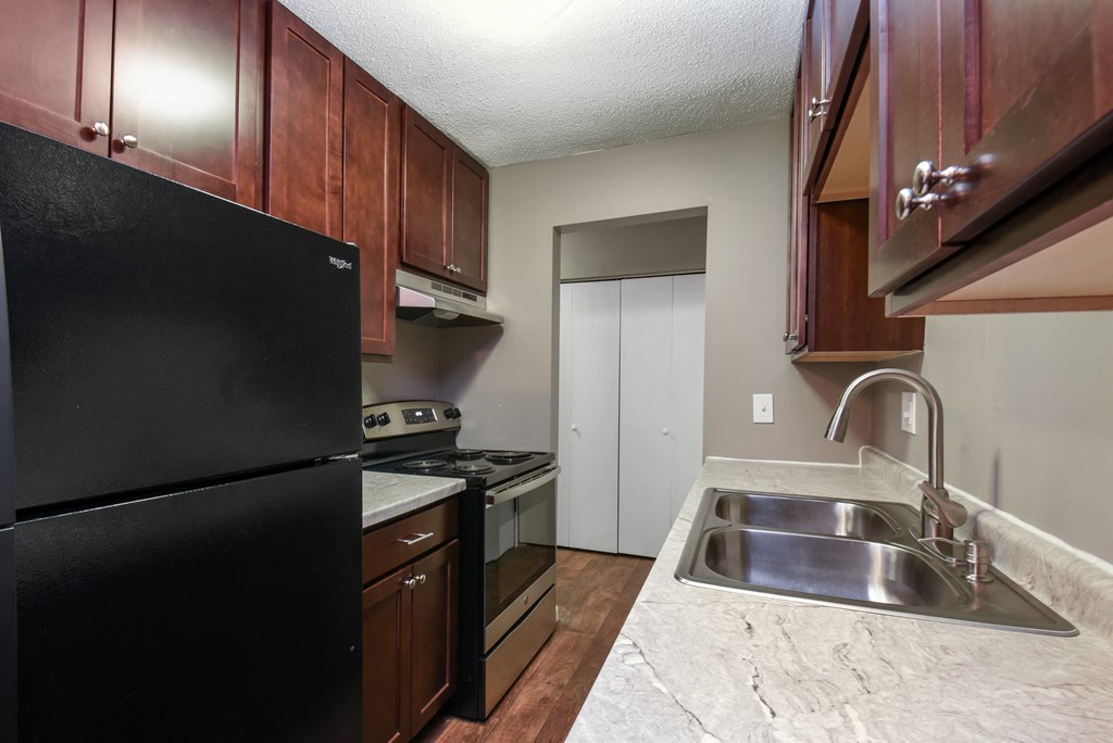 a kitchen with a sink and a stove and a refrigerator. Roseville, MN Rosedale Estates