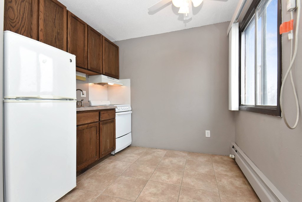 an empty kitchen with a refrigerator and a window. Roseville, MN Rosedale Estates