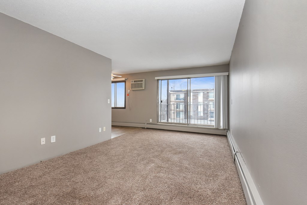 the living room of an empty house with a large window. Roseville, MN Rosedale Estates