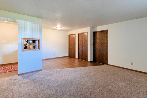 an empty living room with wood floors and white walls