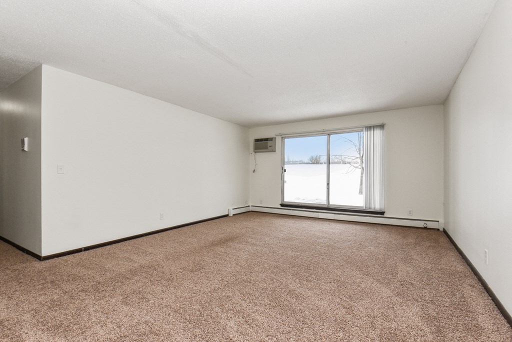 New Brighton, MN Sage Park Apartments. a bedroom with a large window and a carpeted floor
