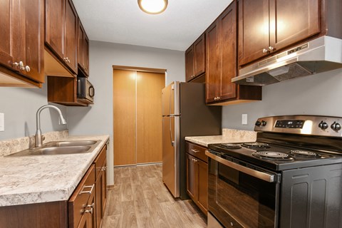 a kitchen with wooden cabinets and stainless steel appliances