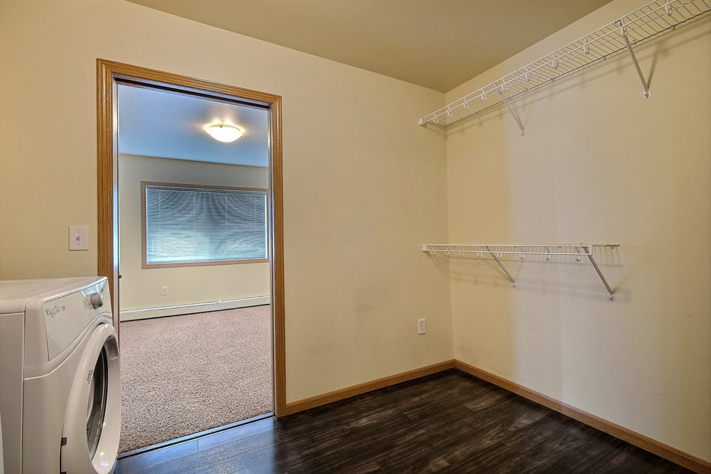 an empty laundry room with a washer and dryer. Moorhead, MN Sandy Creek Apartments