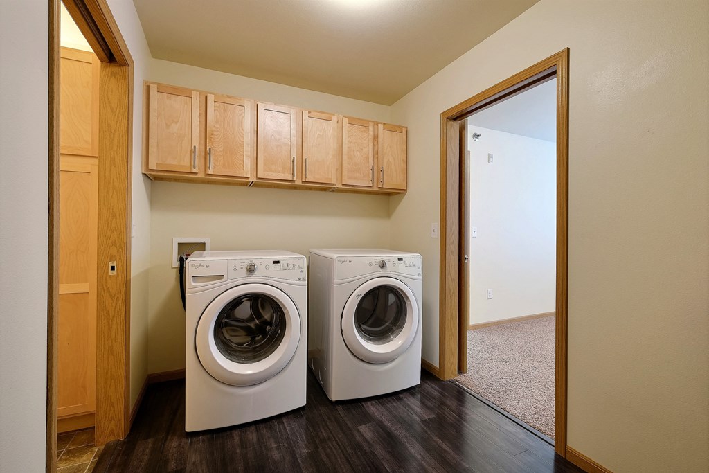 a laundry room with a washing machine and a dryer in it. Moorhead, MN Sandy Creek Apartments