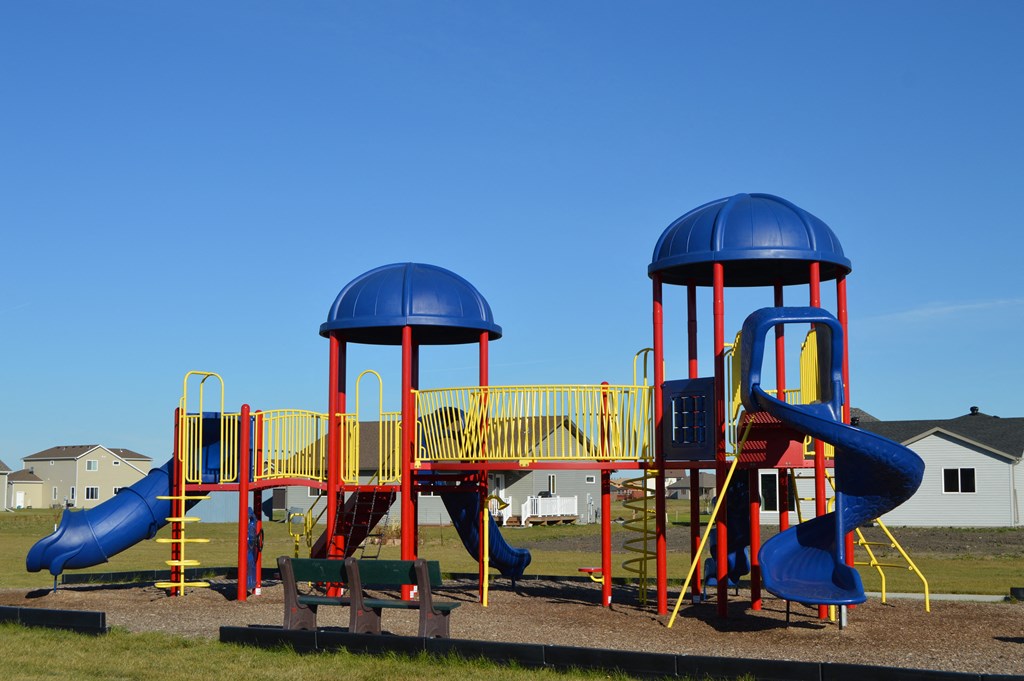 a playground with multiple slides. Moorhead, MN Sandy Creek Apartments