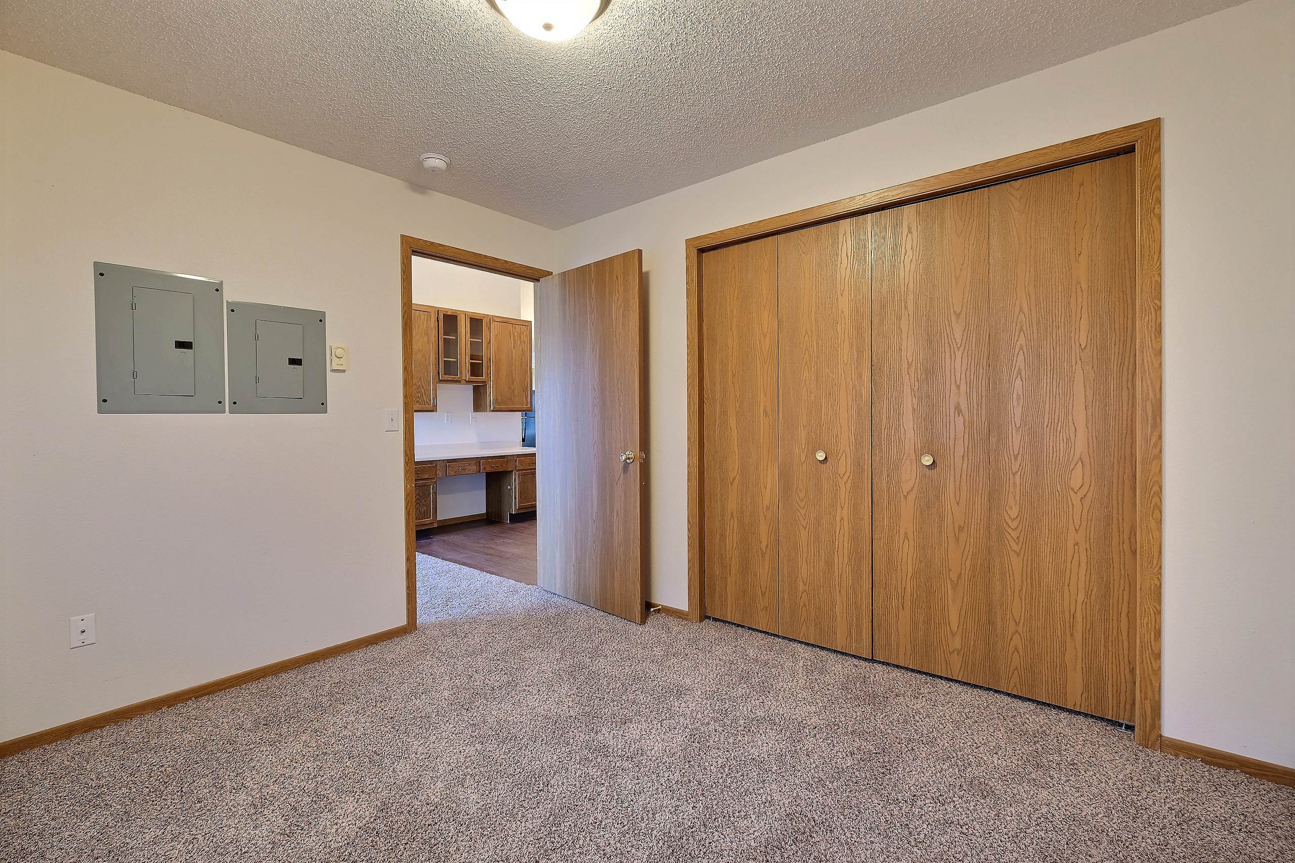 a bedroom with a closet and a door to a hallway. Fargo, ND Somerset Apartments