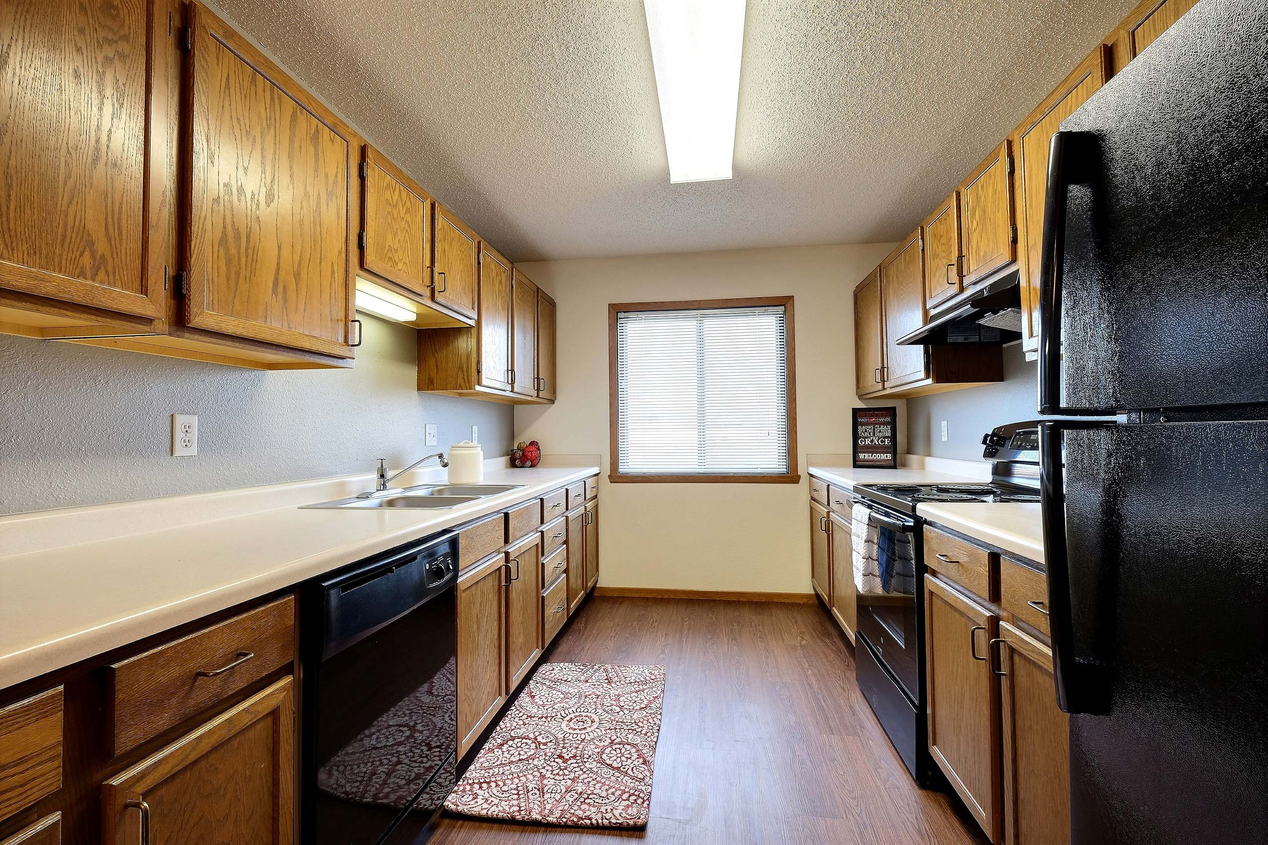 a kitchen with black appliances and white countertops. Fargo, ND Somerset Apartments