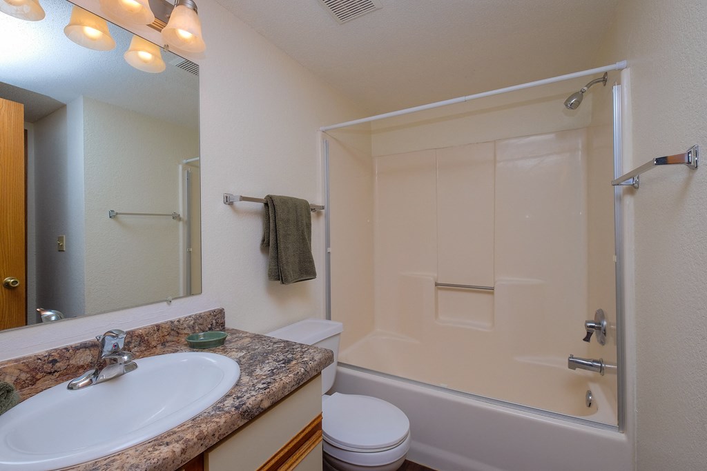 a bathroom with a sink and a toilet and a shower. Fargo, ND South Pointe Apartments